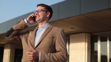 Genç başarılı bir iş adamı gözlük görüşmelerde bir akıllı telefon.