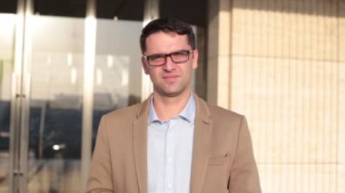 Genç başarılı bir iş adamı bir ofis binasının arka planı portresi.