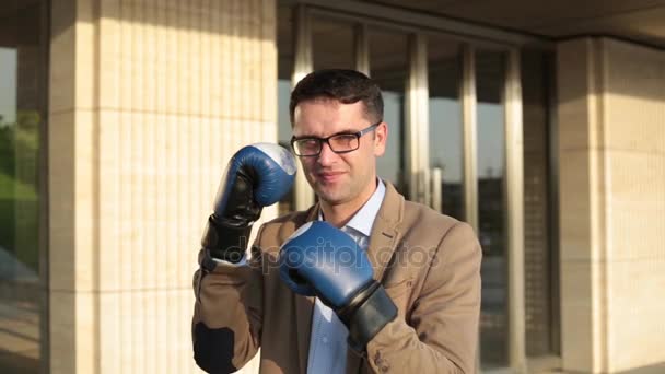 Businessman in suit and boxing gloves strikes. — Stock Video