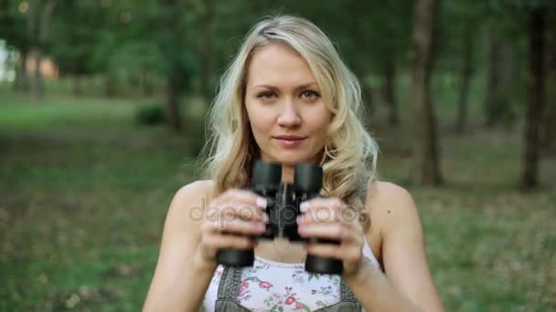 Beautiful woman looks through binoculars. — Stock Video