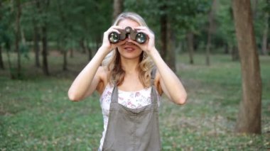 Genç bir kadın dürbün ile görünüyor. Dürbün ile kız.