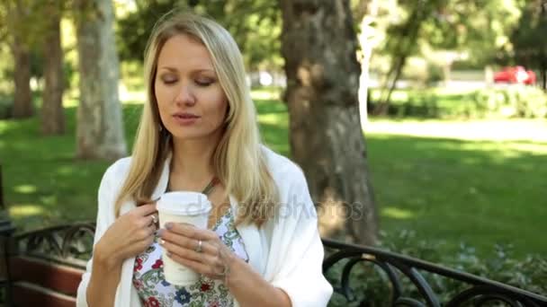 Hermosa mujer está bebiendo café al aire libre . — Vídeo de stock