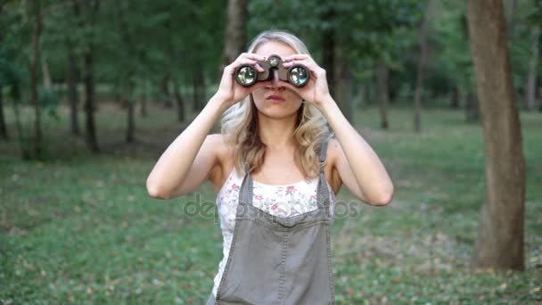 Een vrouw in het bos ziet er door middel van verrekijkers. — Stockvideo