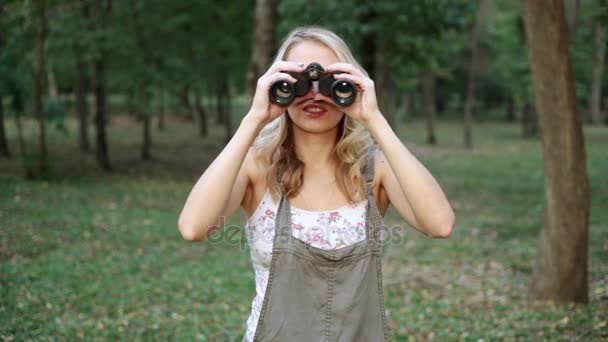 Woman with binoculars. The girl looks through binoculars. — Stock Video