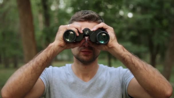 Un hombre con prismáticos en el bosque . — Vídeo de stock