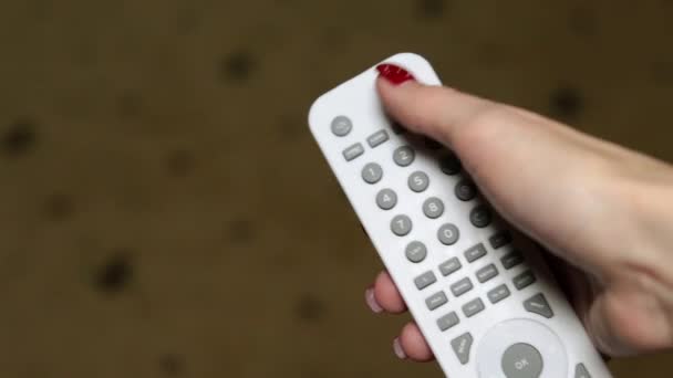 Женщина переключает пульт от телевизора — стоковое видео