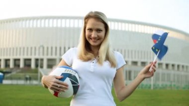 Bir kadın bir futbol ile Rusya ve Avrupa Birliği bayrakları tutar. Rusya 2018 Dünya Kupası.