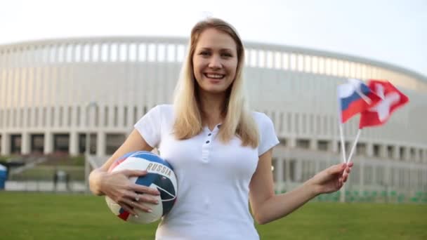 Animadora de fútbol con una pelota. Mujer con la bandera de Rusia y Suiza . — Vídeo de stock