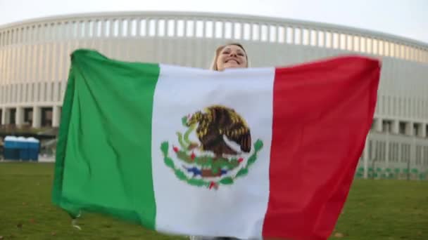 Mujer con gran bandera de México. Futbolista de México en el fondo del estadio . — Vídeos de Stock