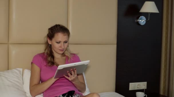 ベッドの上のタブレット コンピューターを持つ女性. — ストック動画