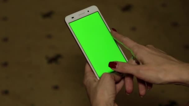 Una donna tiene in mano uno smartphone con uno schermo verde . — Video Stock