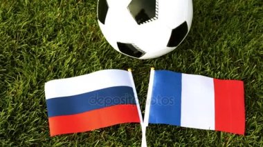 Futbol topu ve bayraklar, Rusya ve Fransa. Futbol, top çimenlerin üzerinde.