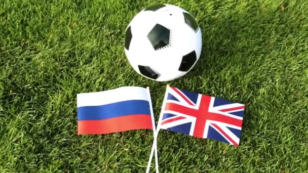 Balón de fútbol y banderas de Rusia y el Reino Unido. Fútbol, pelota en el césped, Copa del Mundo 2018 . — Vídeo de stock