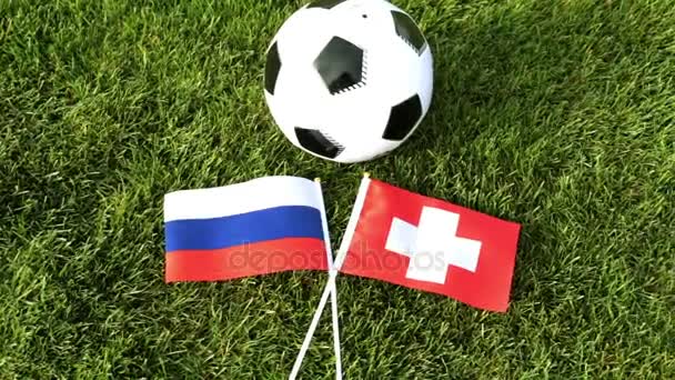 Balón de fútbol y banderas de Rusia y Suiza. Fútbol, pelota en el césped, Copa del Mundo . — Vídeo de stock