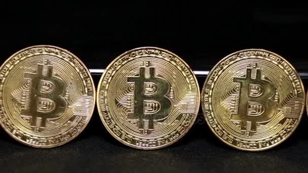 Monedas de oro bitcoins sobre un fondo negro . — Vídeo de stock