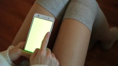 Bir kadın bir smartphone yeşil bir ekran ile tutuyor. Bir akıllı telefon içeriğiniz için yeşil bir ekran ile.