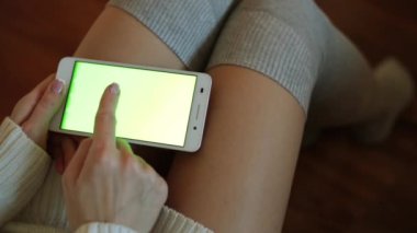 Bir akıllı telefon içeriğiniz için yeşil bir ekran ile. Bir kadın bir smartphone ile yeşil bir ekran tutuyor.