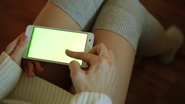 En smartphone med en grön skärm för ditt innehåll. En kvinna håller en smartphone med en grön display. — Stockvideo