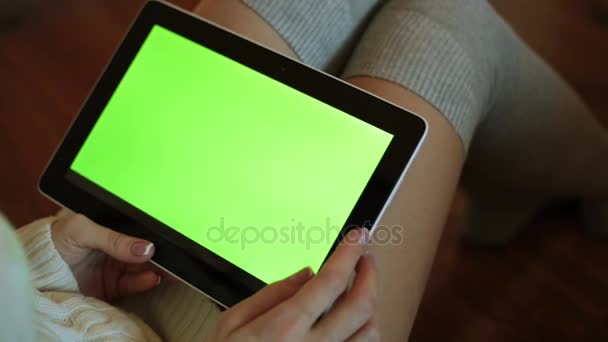 Uma mulher está segurando um tablet com uma tela verde . — Vídeo de Stock