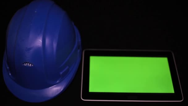 Ένα tablet με μια πράσινη οθόνη και κατασκευής κράνος. — Αρχείο Βίντεο