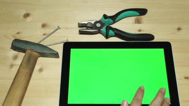 Herramientas de mano para reparaciones y una tableta. Alicates, martillo y tableta con pantalla verde . — Vídeos de Stock