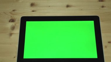 Bir adam jestleri eliyle tablet bilgisayar ile yeşil bir ekran üzerinde yapar.