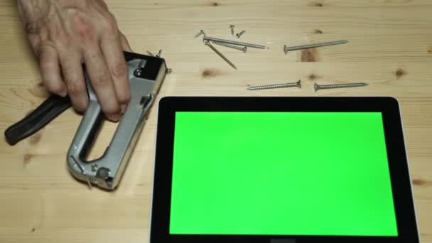 Ein Bauhefter, ein Schraubenzieher und ein Tablet-Computer mit grünem Display. — Stockvideo