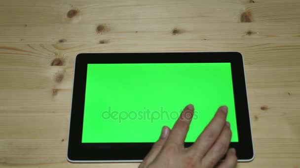 Tablet computer con uno schermo verde sullo sfondo di un tavolo di legno . — Video Stock