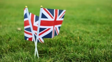 Birleşik Krallık bayrağı rüzgârda çırpınıyor. Büyük Britanya bayrağı çimenlerin üzerinde.