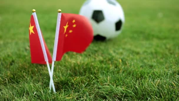 Porzellanfahne und Fußball auf dem Rasen. Chinesische Flagge und Fußball. — Stockvideo