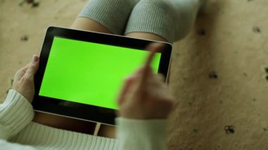 Seksi bir kadın bir tablet içeriğiniz için yeşil bir ekran ile tutuyor.