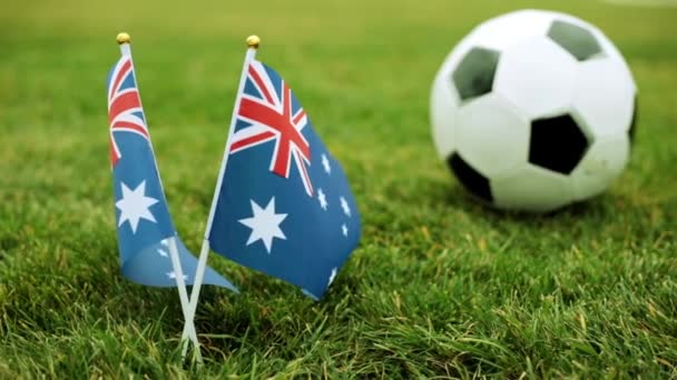 Avustralya ve futbol topu bayrağı. Avustralya bayrağı ve topu çimenlerin üzerinde. — Stok video