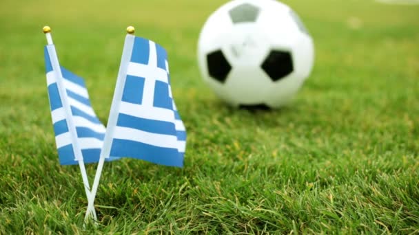 Vlajka Řecka a fotbalový míč. Řecká vlajka a fotbalový míč na trávě. — Stock video