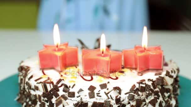 Een vrouw kaarsen op een taart uitblazen. Verjaardag, cake met kaarsen. — Stockvideo