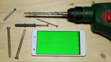 Bina perforator ve yeşil bir ekran ile smartphone.