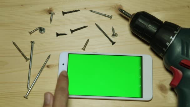 Elektrikli tornavida ve yeşil bir ekran ile smartphone. — Stok video