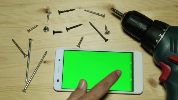 Destornillador eléctrico y smartphone con pantalla verde para tu contenido . — Vídeo de stock