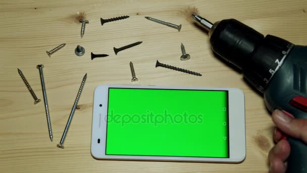 Strumenti di costruzione e uno smartphone con schermo verde . — Video Stock