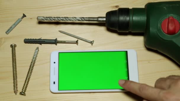 Elektrikli zımba ve yeşil bir ekran ile smartphone. — Stok video