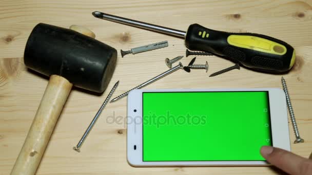 Gebouw tools en een smartphone met een groen scherm. — Stockvideo