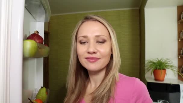 Uma jovem abre uma geladeira e come uvas . — Vídeo de Stock
