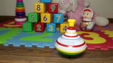 Eğlenceyi yerde dönüyor. Çocuk peg-top oyuncaklar arka planı döner.