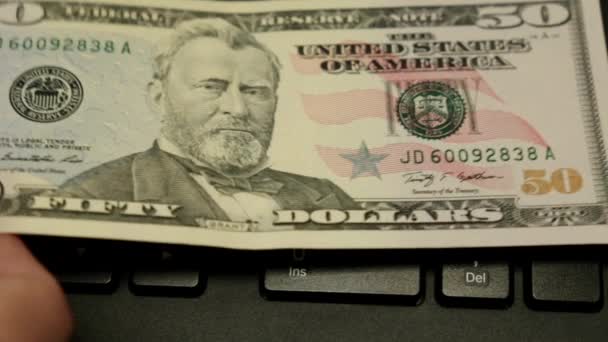 De notitie is 50 Amerikaanse dollar en een bitcoin munt op het toetsenbord. — Stockvideo