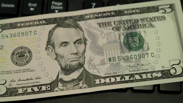 Cinco dólares americanos e uma moeda bitcoin no teclado . — Vídeo de Stock