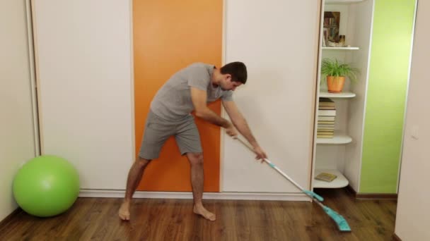 L'homme fatigué lave le sol avec une serpillière — Video
