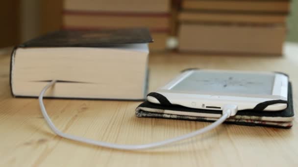 El e-book está conectado por un cable con un libro de papel . — Vídeo de stock