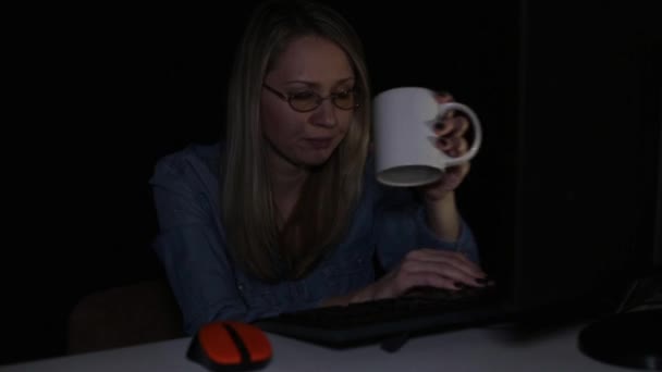 Tired woman works at the computer at night. — Stock Video