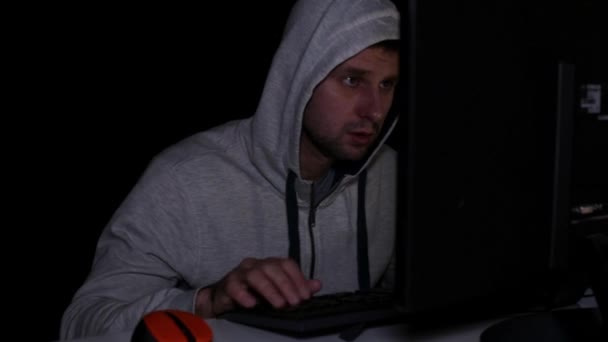 Un hacker hombre en el ordenador en la oscuridad . — Vídeo de stock
