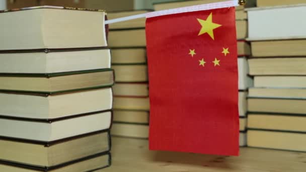Kínai zászló a háttérben a könyvek. A kínai zászló és papír könyv. — Stock videók