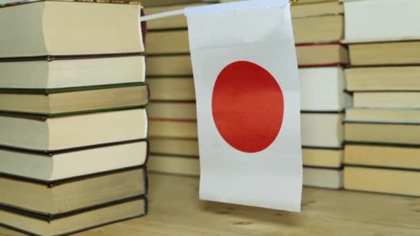 Japán zászló és papír könyvek. Japán zászló a háttérben a könyvek. — Stock videók